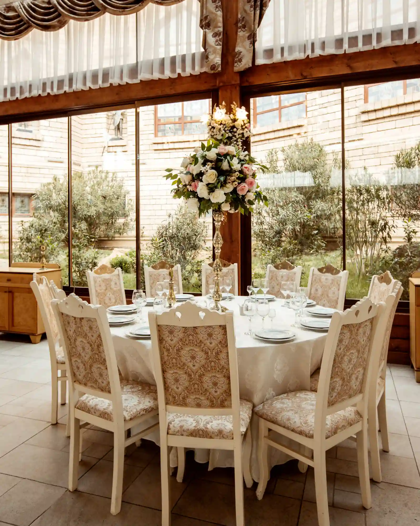 party area with white covered table surrounded by white covered chairs of an event rentals in dubai