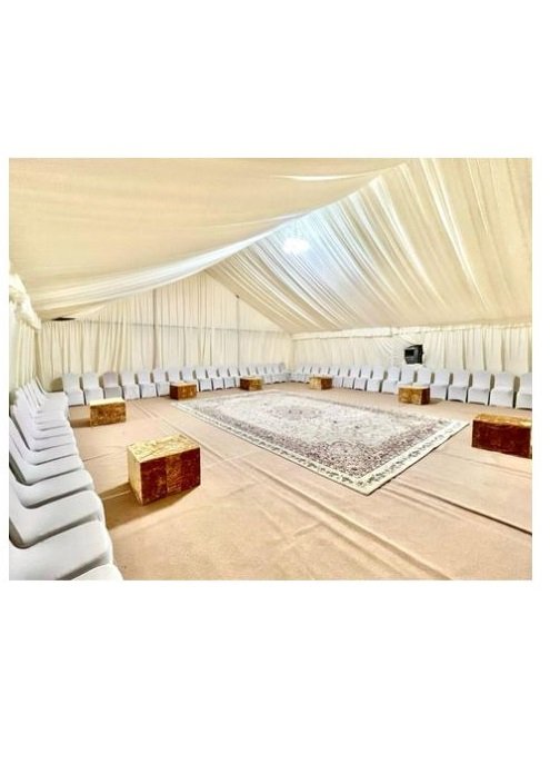 inside of an outdoor a/c tent with white carpets and cushions