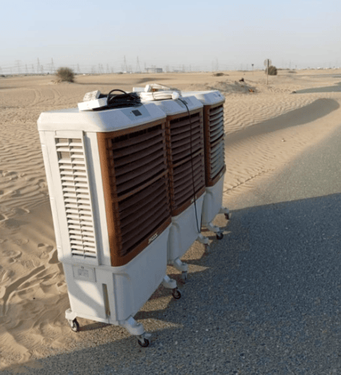 three white colored coolers standing on a desert roadside