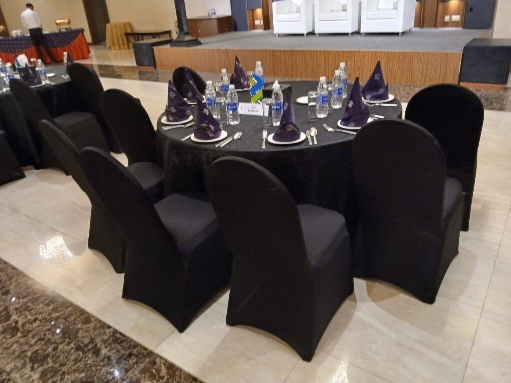 round table with black cover with black covered chairs