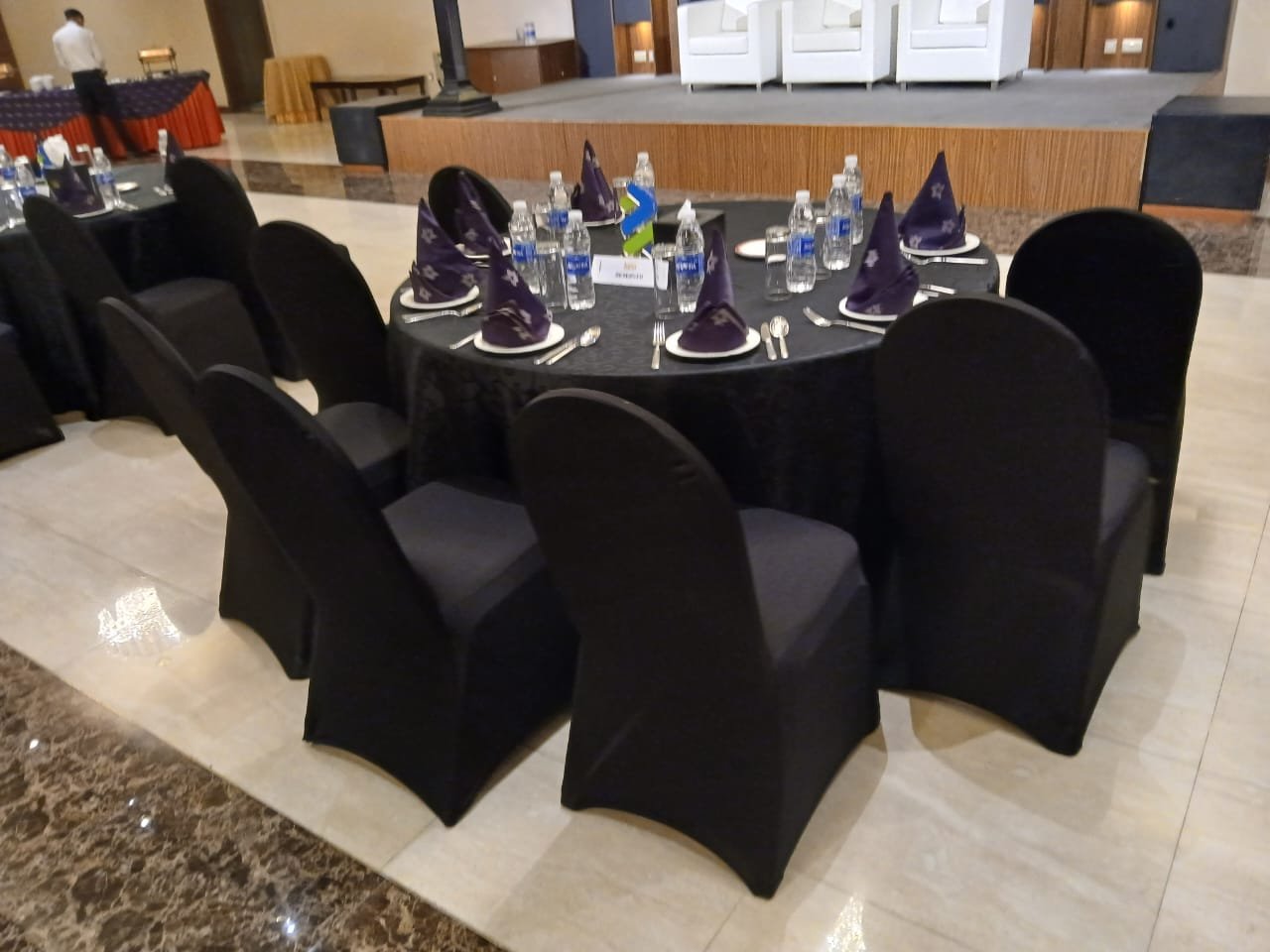 round table with black cover with black covered chairs